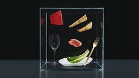 Izbor jedilnega pribora, krožnikov in živil v stekleni kocki za predstavitev stebra doživetij Taking Taste Further.