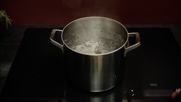 Pot on hob with boiling water